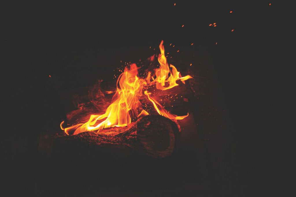 A cozy image of a burning fireplace with dancing flames and glowing embers.