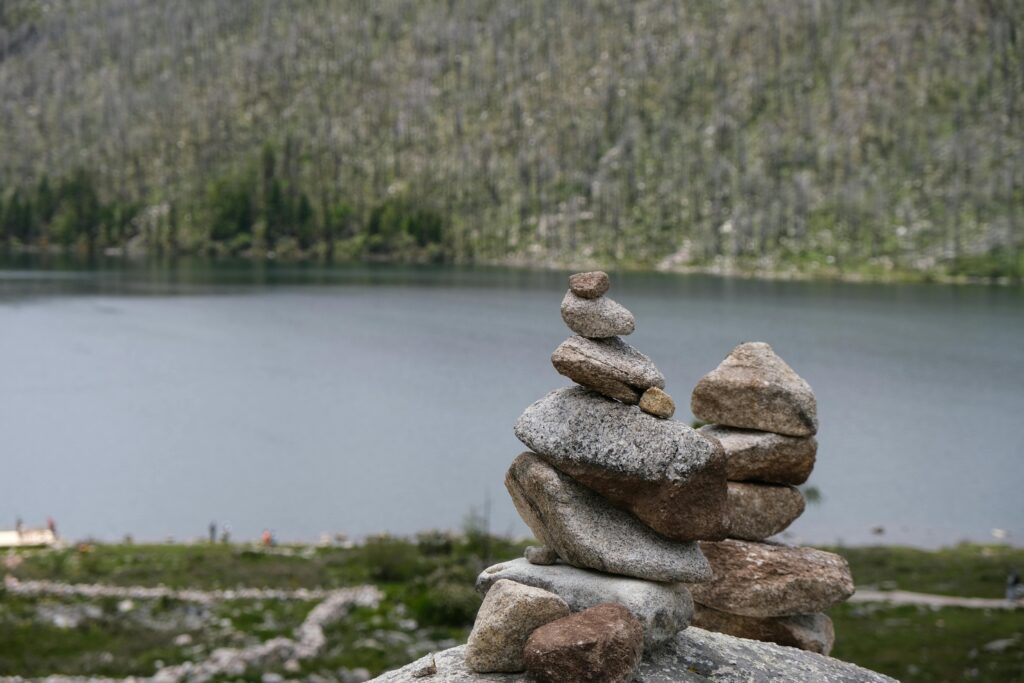 DAY 52 - THE UNCUT STONES A peaceful stone stack by a calm lake in China, perfect for zen and tranquility themes.