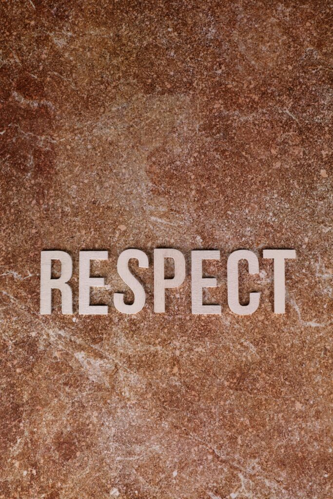 Word 'Respect' displayed on a textured brown marble surface, emphasizing equality.