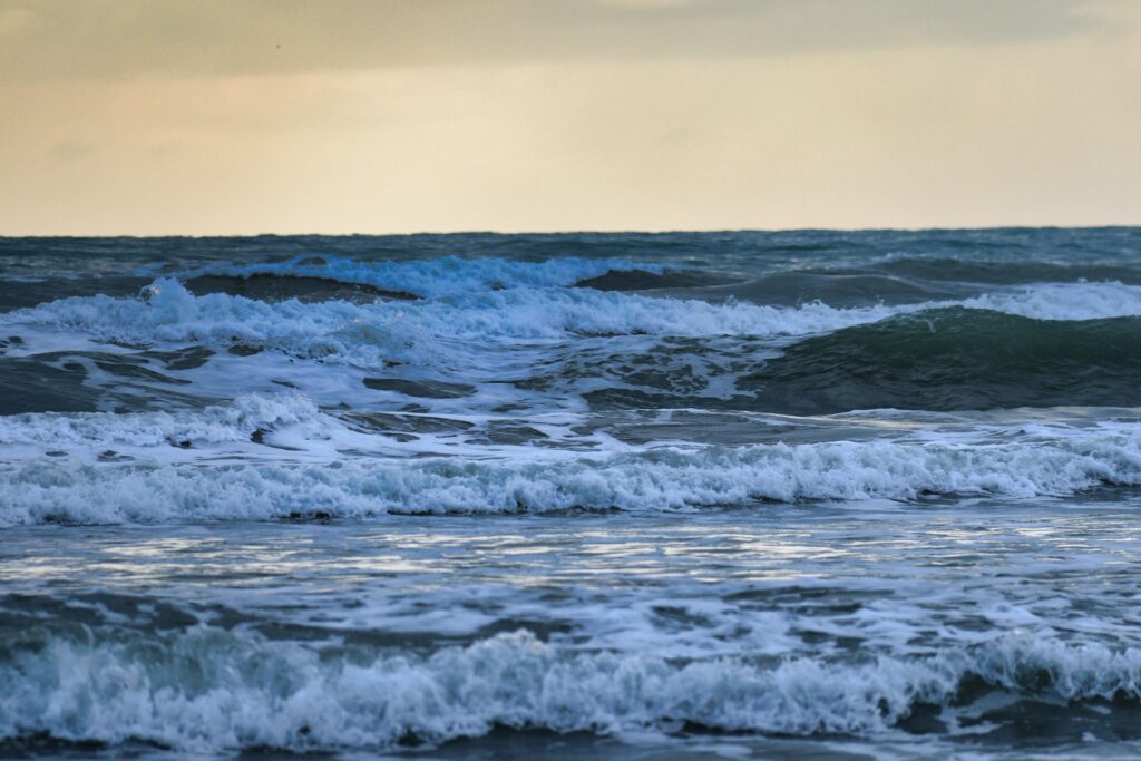 Capture of powerful ocean waves crashing under a moody, overcast sky.