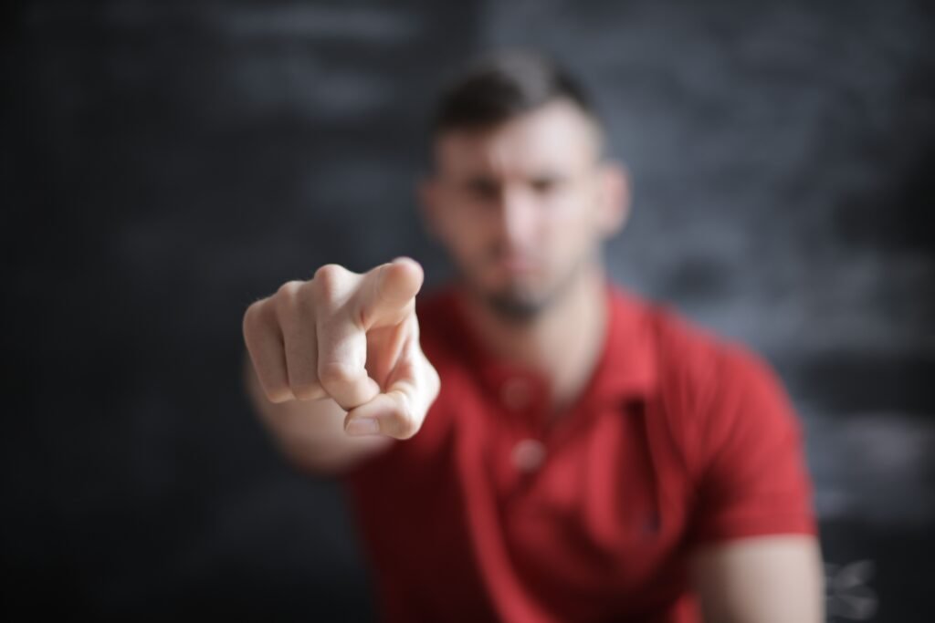 Blurred man pointing forward, emphasizing index finger close-up.