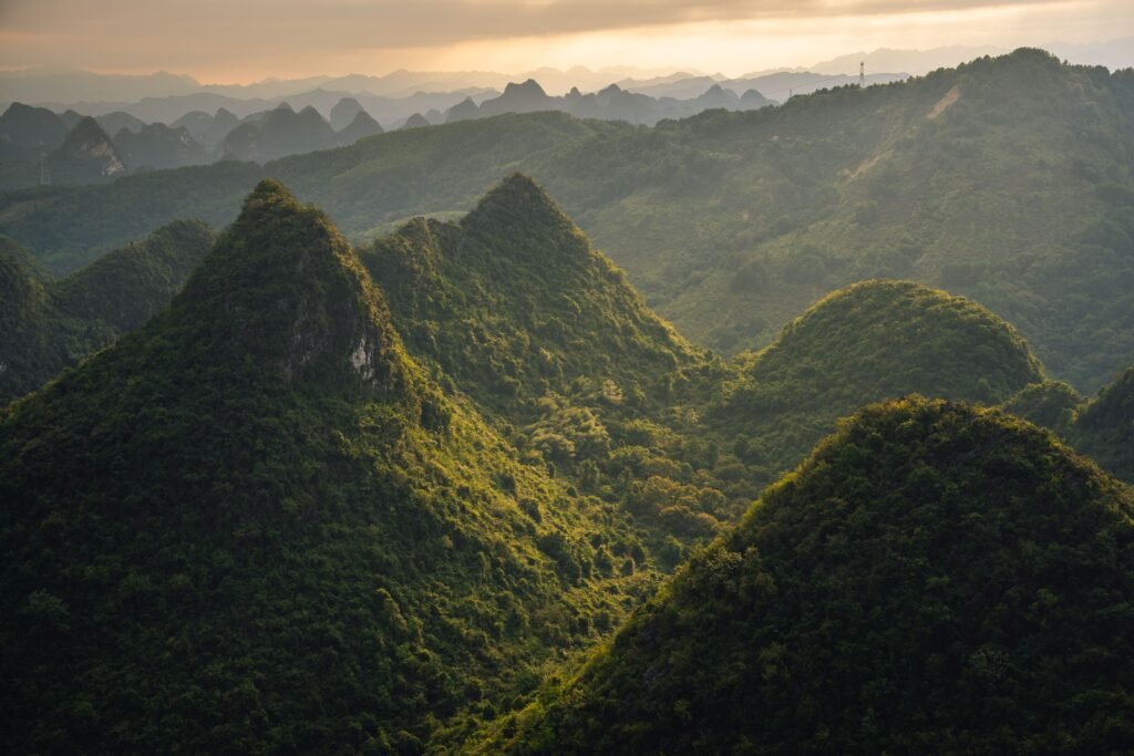 Stunning aerial view of lush green karst mountain landscape in Guilin, Guangxi, China during sunset.