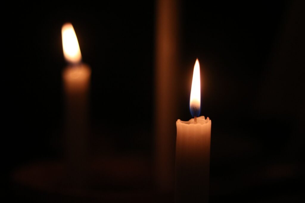 Soft candle flames illuminate the darkness, creating a peaceful atmosphere.