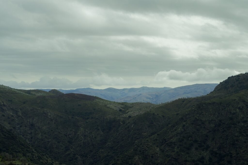 30 SEPTEMBER 2026, DAY 273 -FINDING OUR WORTH IN GOD A tranquil view of green mountains under a cloudy sky, capturing a serene natural landscape.